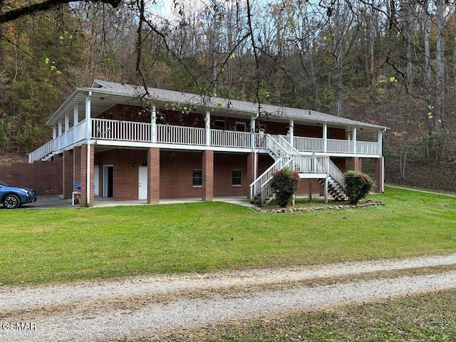 view of front of property with stairs, a front lawn, and a wooded view