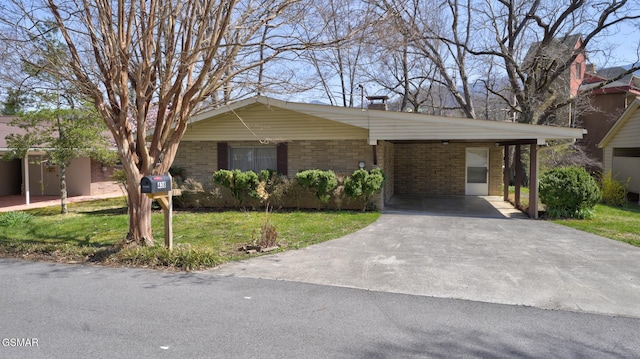 view of front of home featuring a front lawn, a carport, brick siding, and concrete driveway