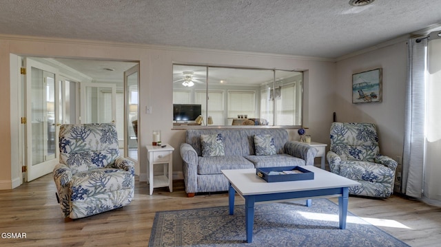living area featuring a textured ceiling, ornamental molding, and wood finished floors