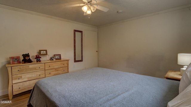 bedroom with crown molding, ceiling fan, and wood finished floors