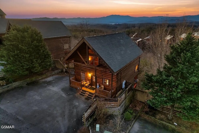 exterior space featuring roof with shingles, a mountain view, and faux log siding