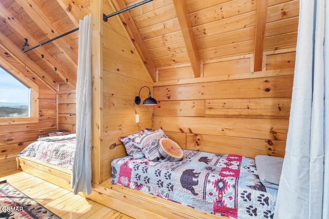 bedroom with wooden ceiling, vaulted ceiling with beams, hardwood / wood-style flooring, and wood walls