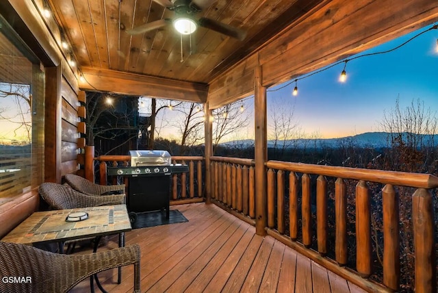 deck at dusk with a ceiling fan and a grill