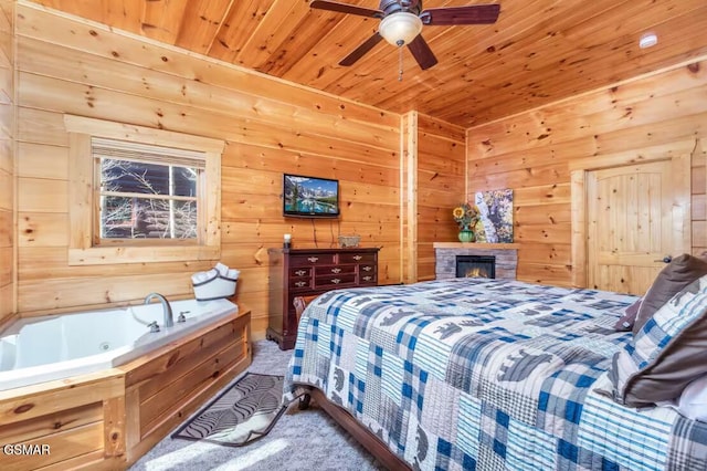 bedroom featuring wood walls, ceiling fan, carpet, and wood ceiling