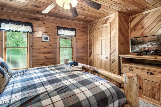 carpeted bedroom featuring wooden ceiling, wooden walls, and ceiling fan