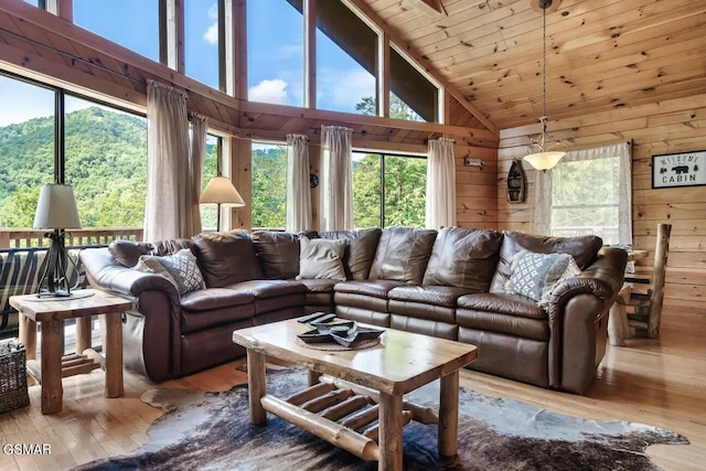 living room featuring high vaulted ceiling, light hardwood / wood-style flooring, and wooden walls