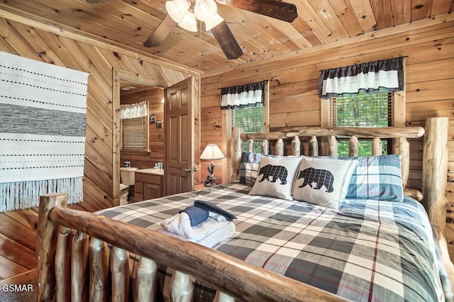 bedroom featuring connected bathroom, wooden walls, and wooden ceiling