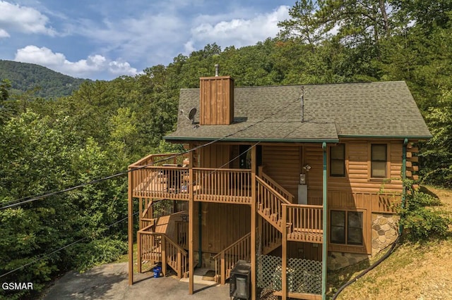 back of property with a deck and a patio