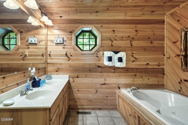 bathroom with a tub, tile patterned floors, vanity, and wooden walls