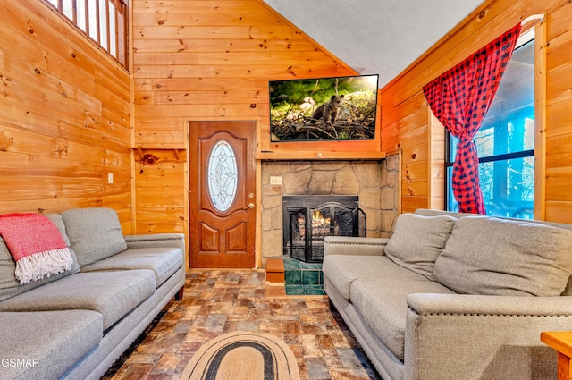 living area featuring plenty of natural light, wooden walls, and a fireplace