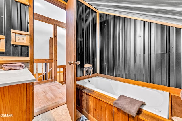 full bathroom featuring a bath and vanity