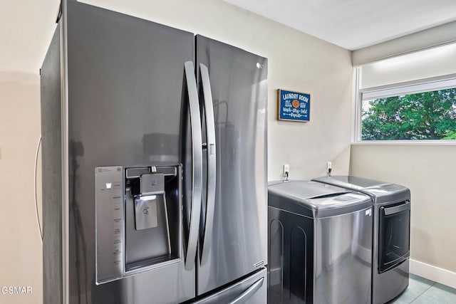 washroom featuring washer and clothes dryer and light tile patterned floors