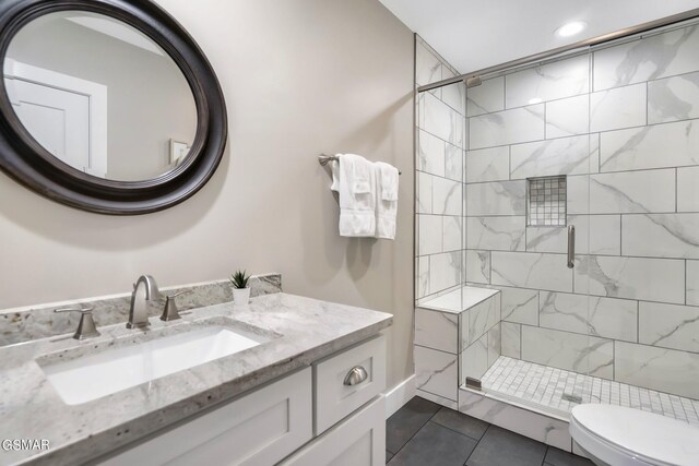 bathroom featuring toilet, vanity, tile patterned floors, and walk in shower