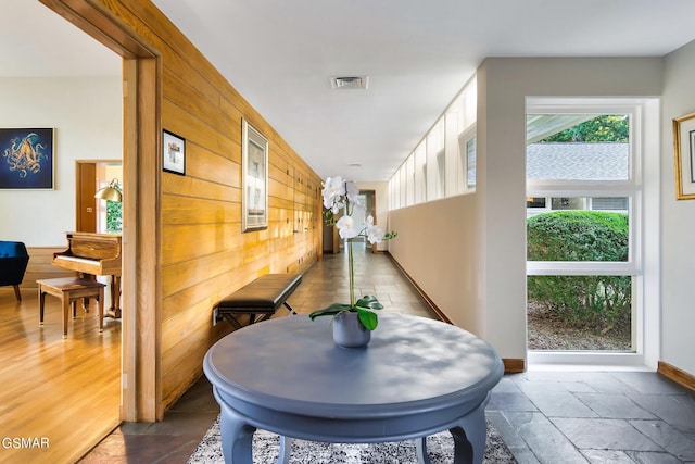 corridor featuring wood walls