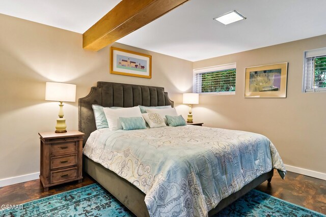 bedroom with beamed ceiling and multiple windows