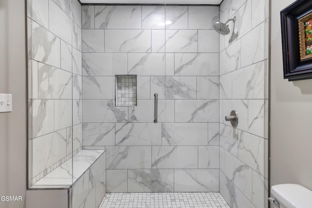 bathroom featuring toilet and a tile shower