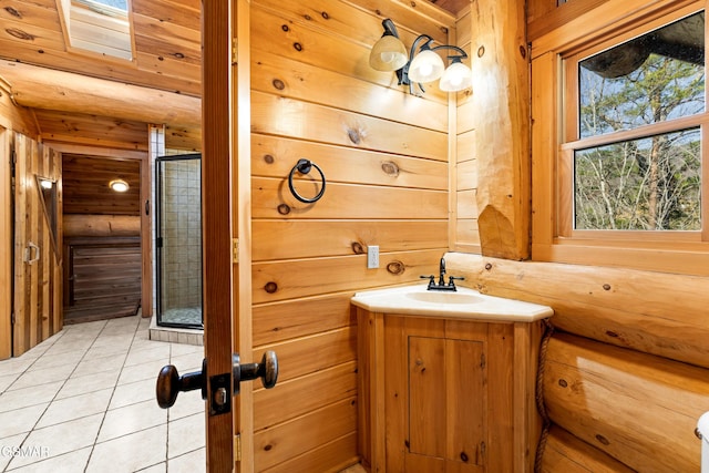 bathroom with a stall shower, vanity, wood walls, and tile patterned floors