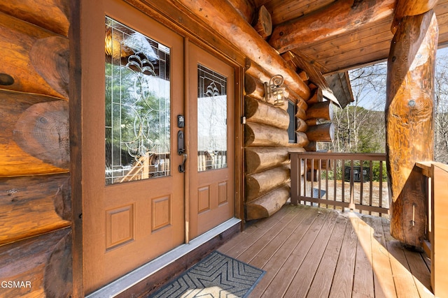 view of exterior entry featuring log siding