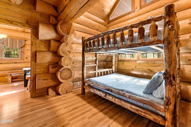 bedroom featuring rustic walls, wooden ceiling, wood finished floors, and lofted ceiling