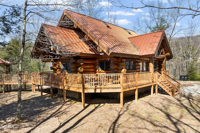 rear view of property with metal roof, a deck, and log siding