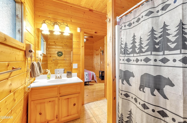 bathroom featuring ensuite bath, wood walls, vanity, and tile patterned flooring