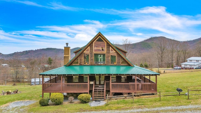 view of front of home featuring a front lawn, a mountain view, and a chimney