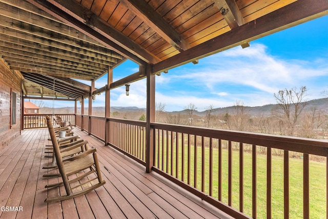 wooden deck featuring a lawn