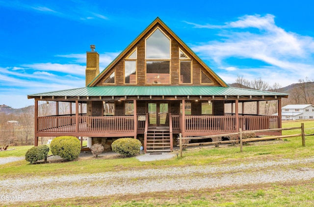 view of front of property featuring metal roof, a mountain view, and a chimney