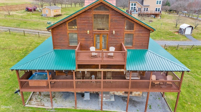 rear view of house featuring a yard, metal roof, a deck, and fence