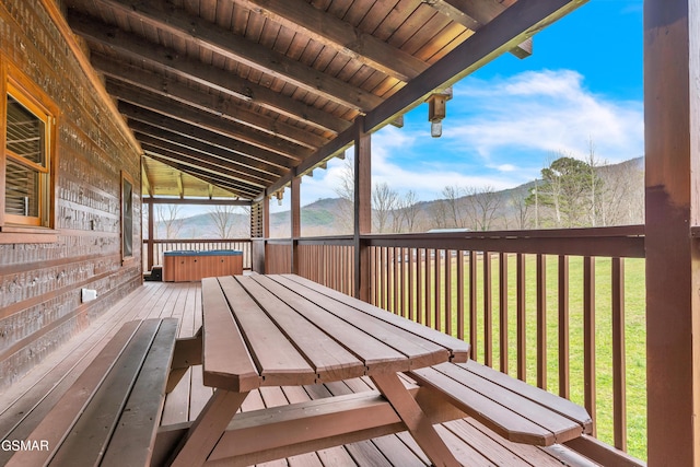 wooden deck featuring a lawn and a hot tub