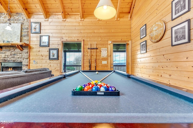 playroom with beam ceiling, wood ceiling, a fireplace, and a healthy amount of sunlight