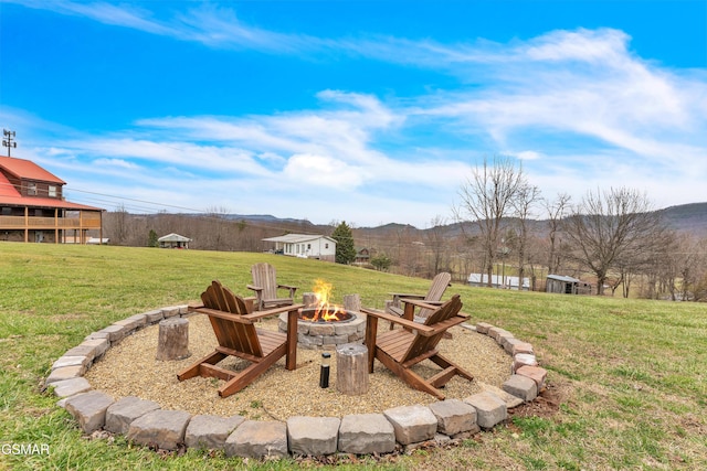 view of yard featuring a mountain view and an outdoor fire pit