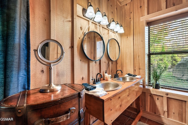 bathroom featuring wood walls, vanity, and a healthy amount of sunlight