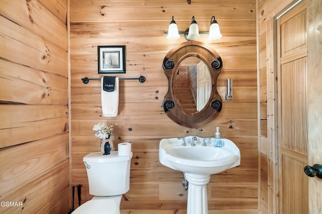 bathroom featuring toilet and wooden walls