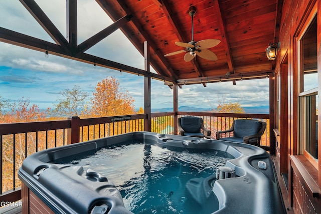 wooden terrace featuring ceiling fan and a hot tub