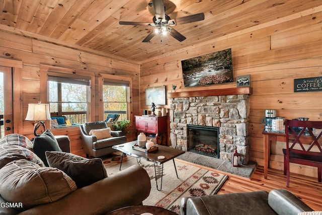 living room featuring wooden walls, a fireplace, wood ceiling, and light hardwood / wood-style flooring