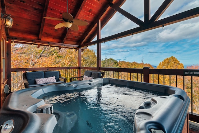 wooden deck with ceiling fan and a hot tub