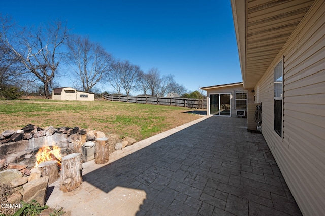 view of yard with an outdoor fire pit, an outdoor structure, a fenced backyard, and a patio