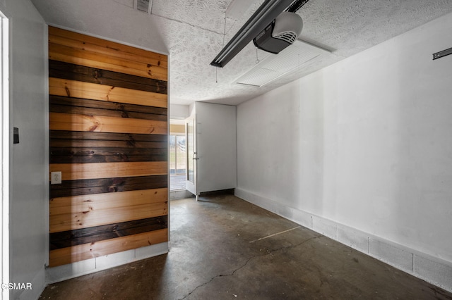 empty room with a sauna, a textured ceiling, visible vents, and unfinished concrete flooring