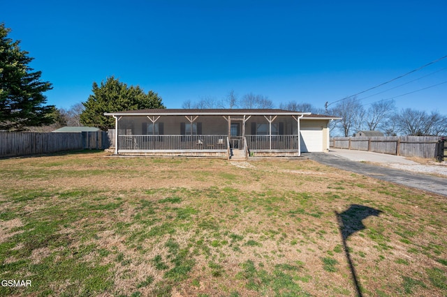 single story home with a garage, a front lawn, fence, and aphalt driveway