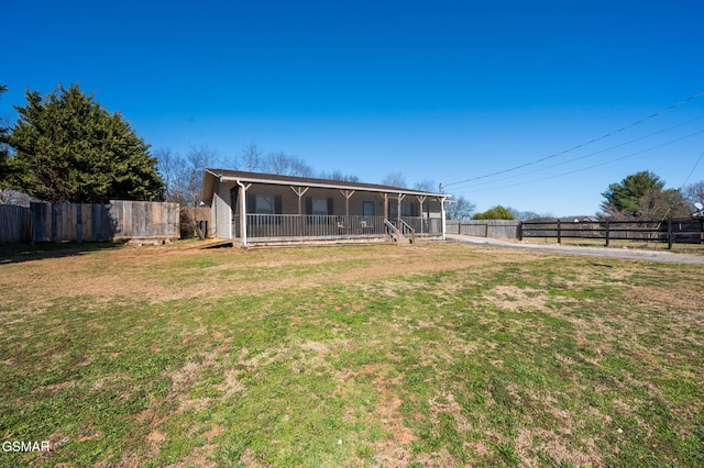 view of front facade featuring a porch, fence, and a front lawn