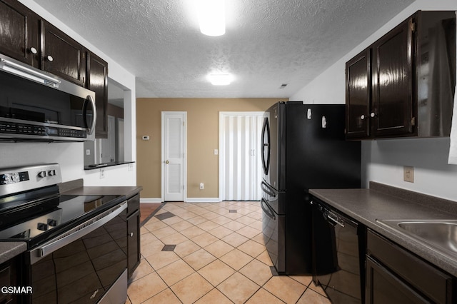 kitchen featuring a textured ceiling, black appliances, light tile patterned floors, and dark countertops