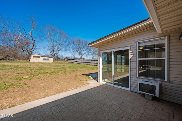 view of patio / terrace featuring a wall unit AC, fence, and an outdoor structure