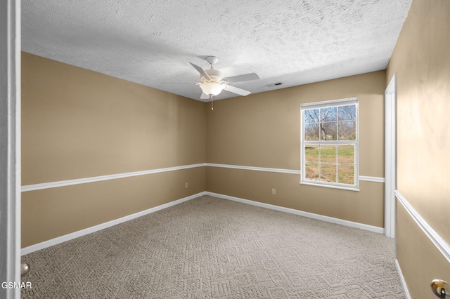 empty room with visible vents, a ceiling fan, carpet flooring, a textured ceiling, and baseboards