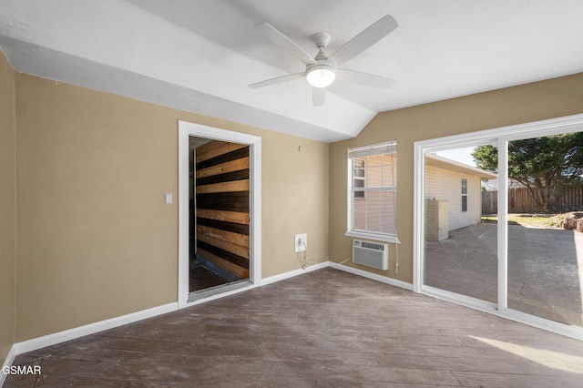 empty room with ceiling fan, baseboards, vaulted ceiling, and a wall mounted AC