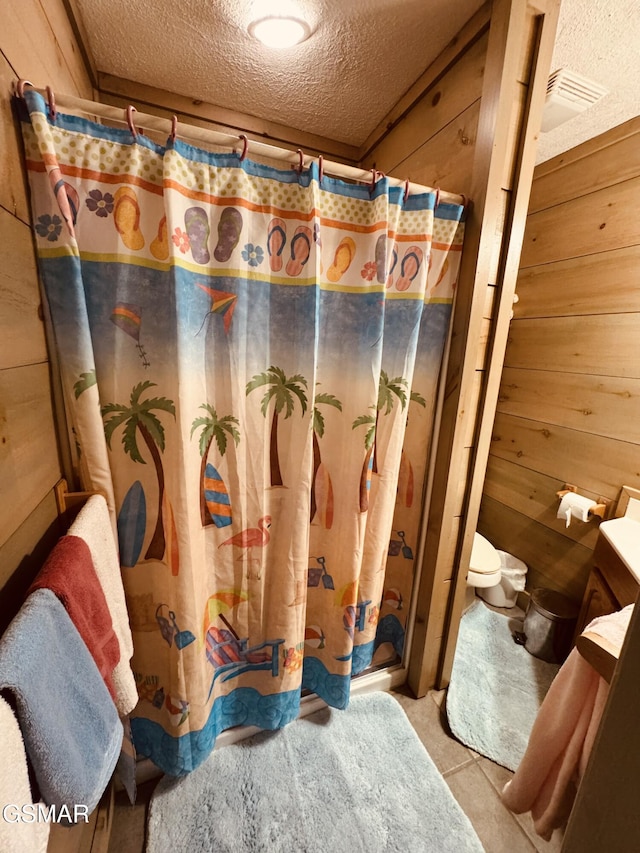 2452 Skyview Way, Dandridge, TN 37725 - bathroom with a textured ceiling, wooden walls, vanity, and curtained shower