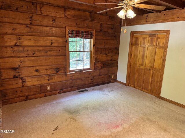 2452 Skyview Way, Dandridge, TN 37725 - unfurnished bedroom featuring wooden walls, carpet, beamed ceiling, a closet, and baseboards
