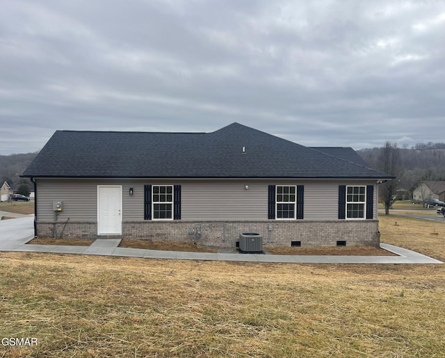 view of front of house featuring cooling unit and a front lawn