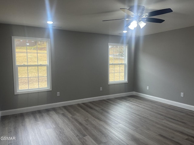 unfurnished room with ceiling fan, a healthy amount of sunlight, and dark hardwood / wood-style flooring