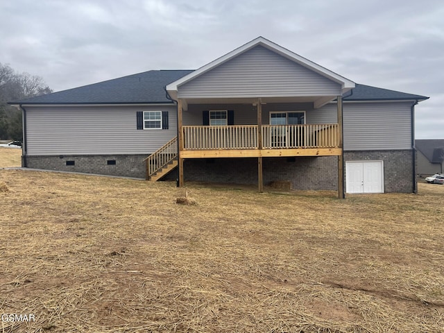 back of property with a deck and a lawn